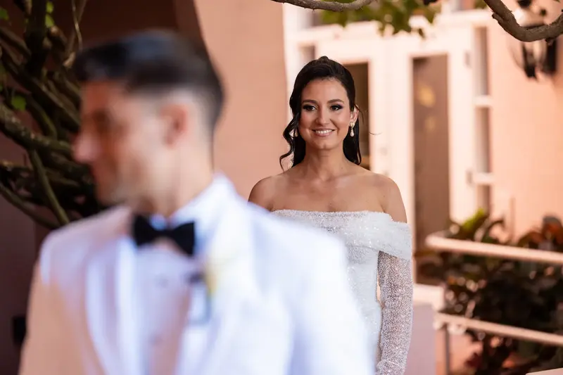 Tayler smiling as she sees Jay for first look in pink courtyard