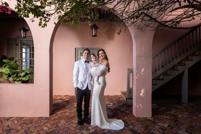 Tayler, Jay, and daughter Gemma family portrait under pink archway