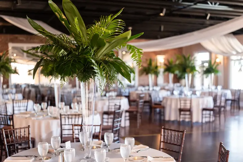 Reception table detail with tall palm leaf centerpieces