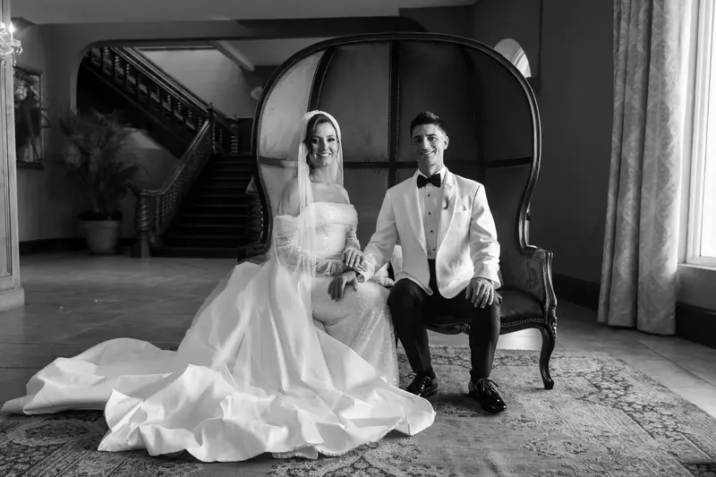 Black and white portrait of couple seated on vintage settee