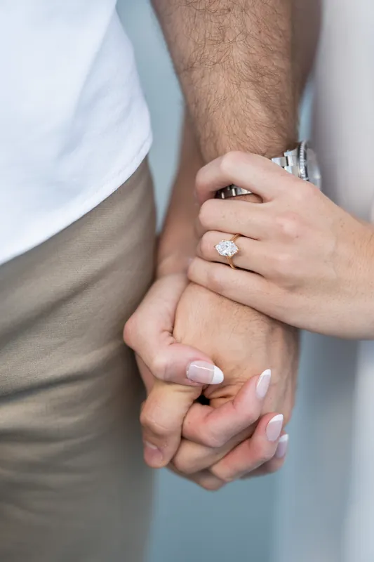 Close-up of two hands holding together, with an engagement ring visible on Colleen's finger.