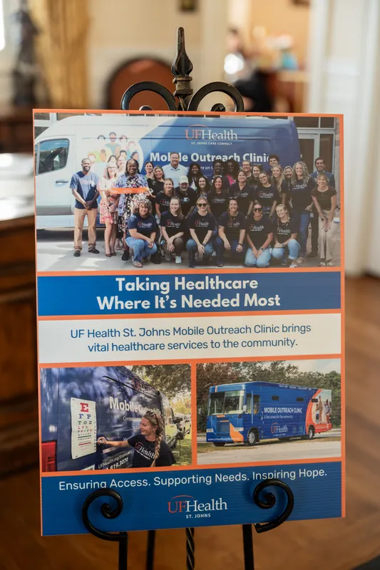 UF Health promotional poster about mobile outreach clinic displayed on an easel at the gala venue.