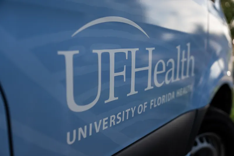 UF Health logo and "University of Florida Health" text appear on the side of a blue vehicle.