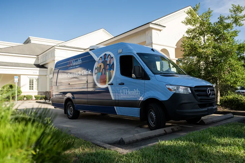 Blue UF Health medical van parked on the grounds outside a white classical building at River House Events, St. Augustine.