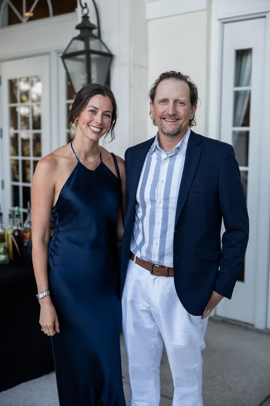 Two guests in formal attire smile together on the patio at River House Events, St. Augustine.