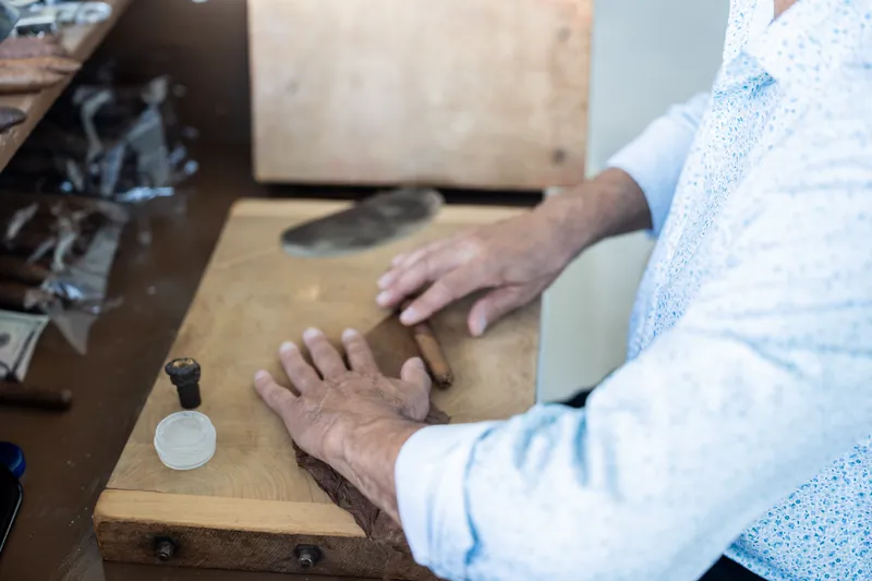 Hands rest on a wooden box as someone inspects its interior.