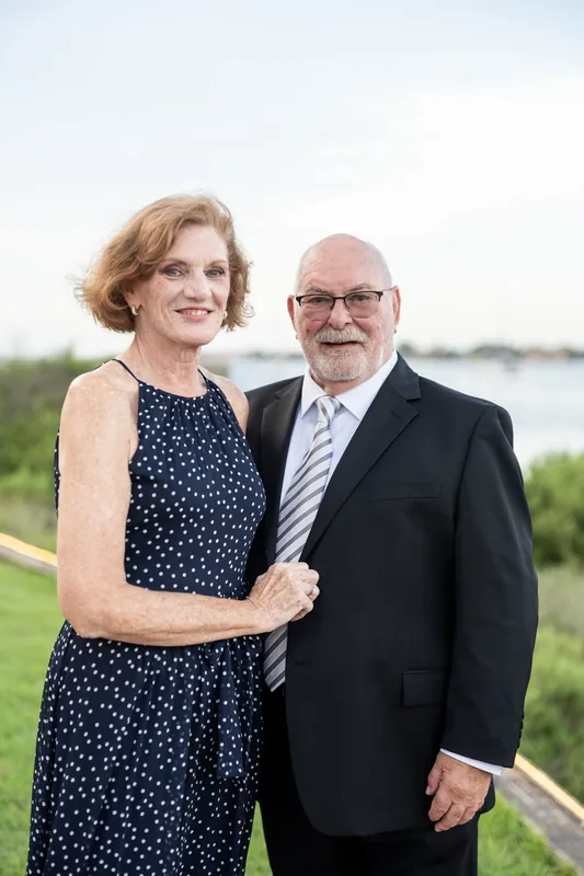 A couple stands arm-in-arm by the water's edge at River House Events, St. Augustine.