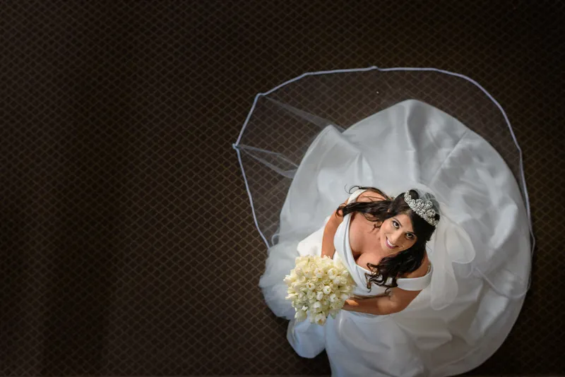 Artistic overhead bridal portrait with veil spread on floor and white bouquet at Castle Ottis