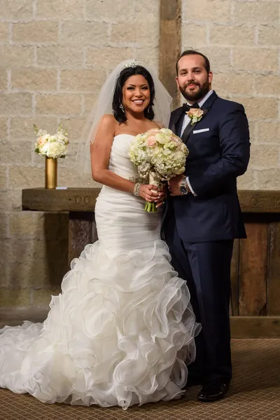 Bride and groom portrait at Castle Ottis altar with white and blush bouquet and coquina walls