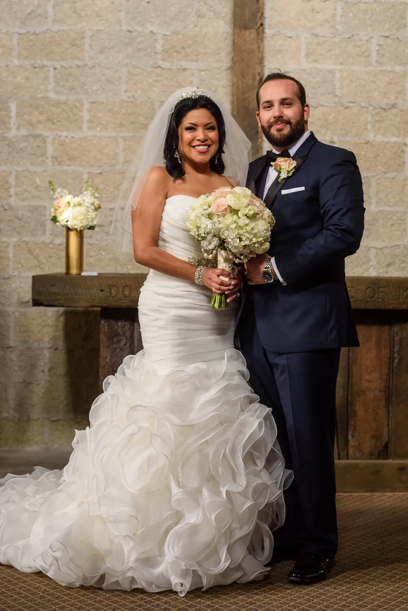 Bride and groom portrait at Castle Ottis altar with white and blush bouquet and coquina walls