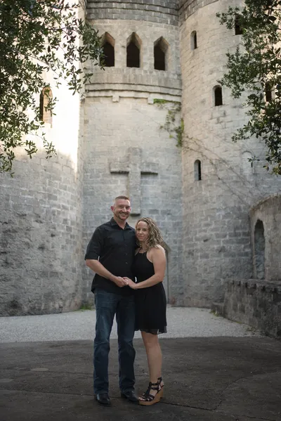 Engaged couple portrait with castle tower exterior and coquina walls at Castle Ottis St. Augustine