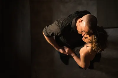 Overhead intimate portrait of couple embracing with dramatic light on coquina floor at Castle Ottis