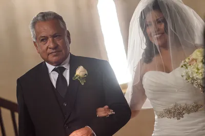 Tender close-up of father and bride smiling during wedding ceremony at Castle Ottis St. Augustine
