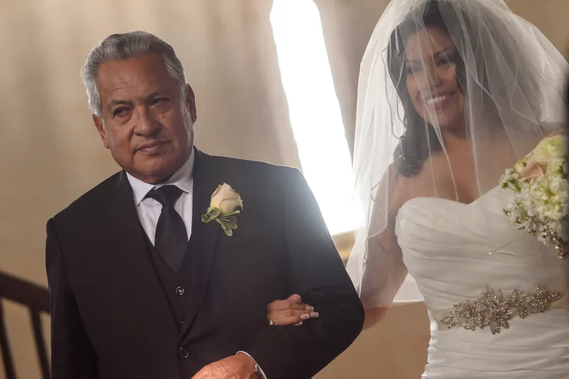 Tender close-up of father and bride smiling during wedding ceremony at Castle Ottis St. Augustine
