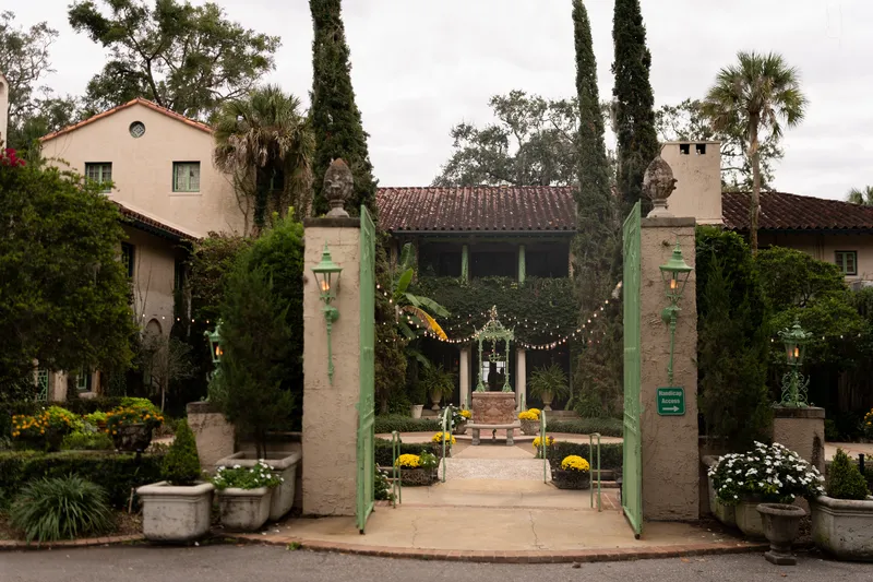 Mediterranean entrance gates at Club Continental decorated with string lights for a fall wedding in Orange Park