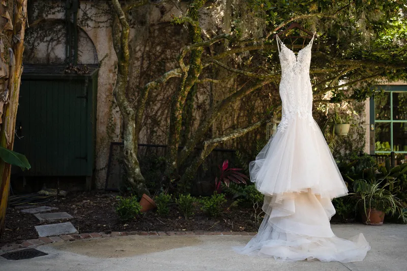 Wedding dress hanging from live oak tree with Spanish moss in the gardens at Club Continental