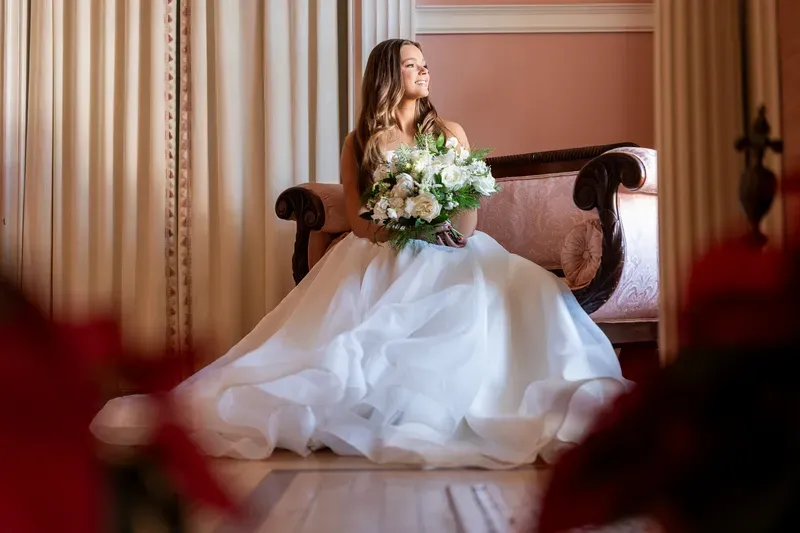 Bridal portrait on antique settee with bouquet at Flagler College