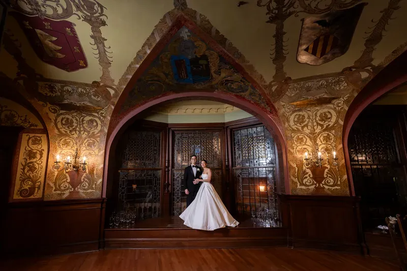 Couple portrait under ornate gothic arch with painted murals at Flagler College