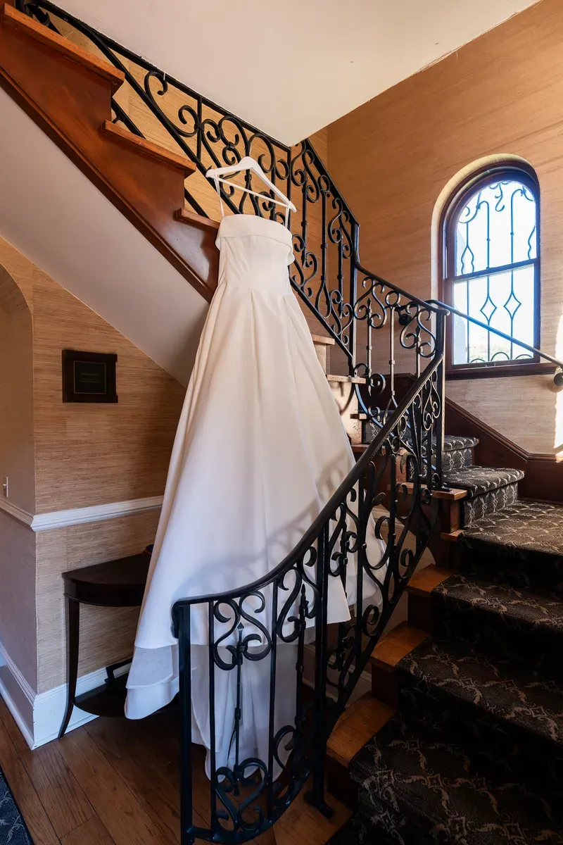Wedding dress hanging on ornate wrought iron staircase at Flagler College St Augustine