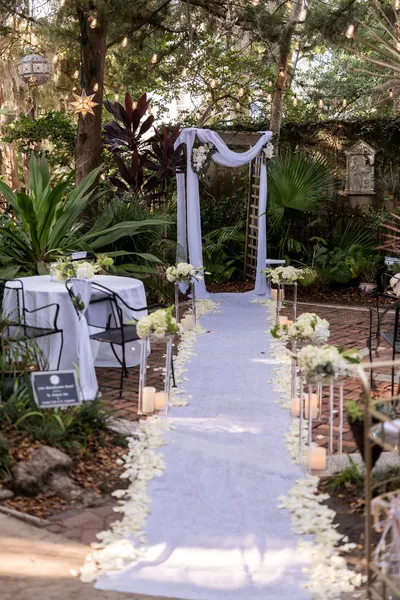 St Francis Inn garden courtyard ceremony setup with white draping and candles