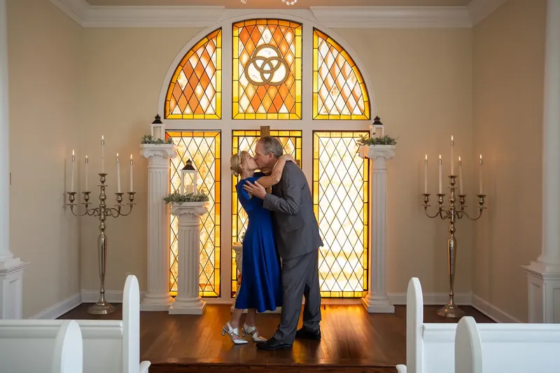 First kiss at Amore Chapel with golden stained glass backdrop St Augustine
