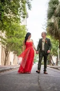Couple walking hand in hand in vibrant dress