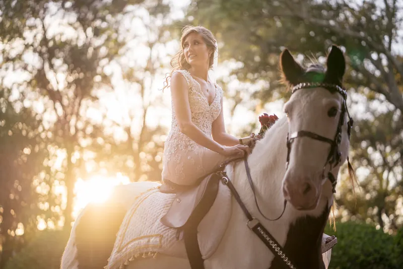 Bride on horseback with sunlight through trees St Augustine