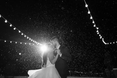 Couple dancing under string lights snowy night at White Room St Augustine