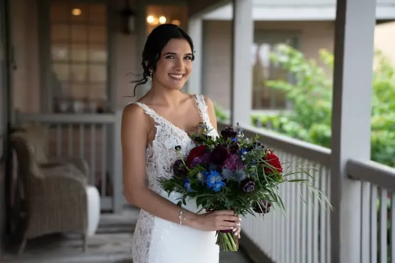 Bride in lace dress with burgundy bouquet at The White Room
