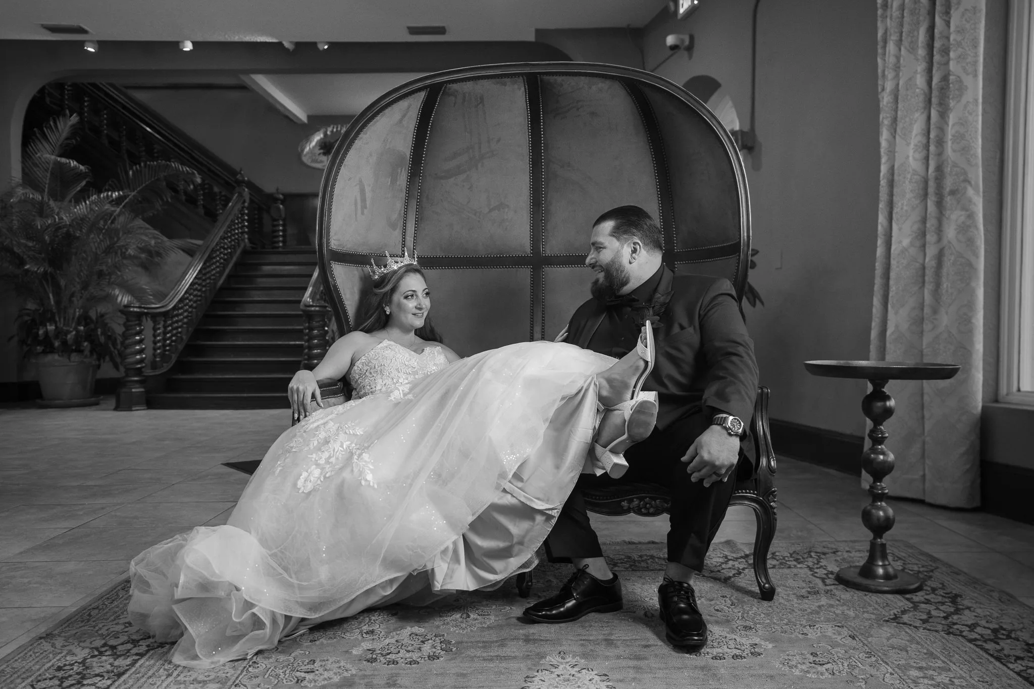 bride and groom sitting on elegant chair at the white room