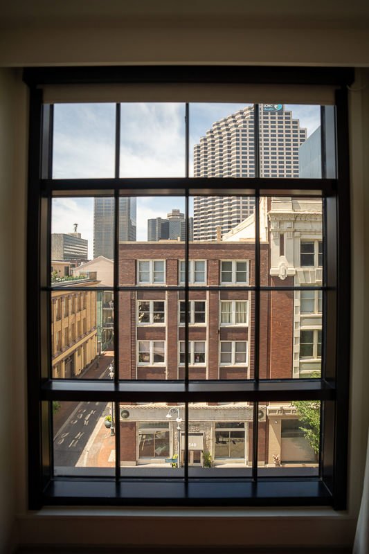 0002_View of city buildings through a large grid window on a sunny day.jpg