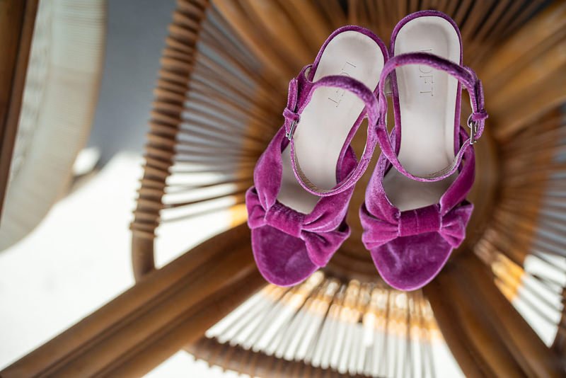 0006_Purple velvet sandals with bows resting on a wooden chair.jpg