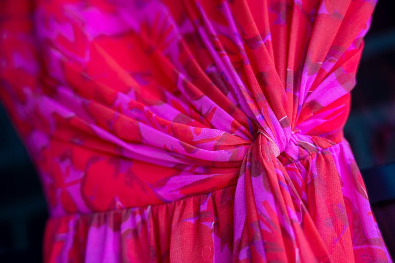 0007_Close up of a vibrant pink and red floral dress with fabric gathered into a knot.jpg