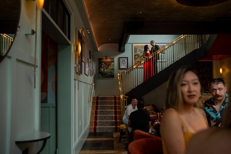 0021_People enjoying a sophisticated evening at a stylish multi level venue with art adorned walls.jpg