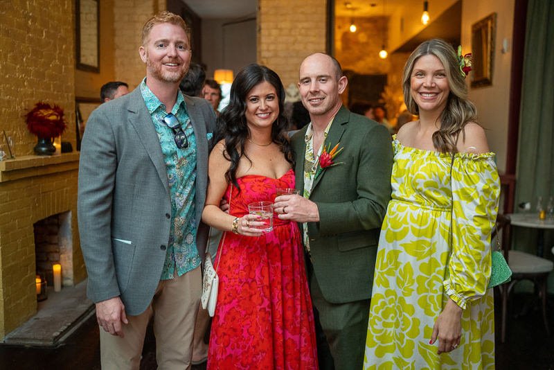 0030_A group of four people posing and smiling together at a festive indoor event.jpg