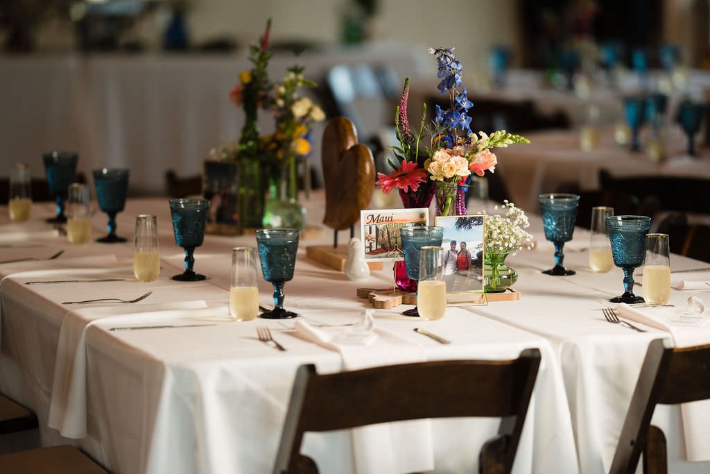 A beautifully set table for a wedding reception complete with flowers personalized touches and a touch of whimsy.jpg
