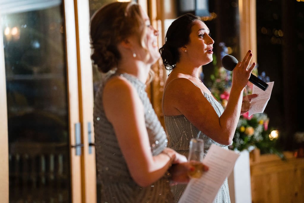 A bridesmaid gives a heartfelt speech at a wedding reception.jpg