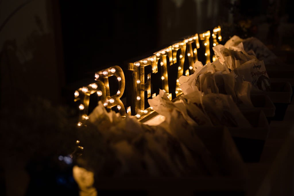 A glowing sign spelling BRITTANY sits atop a stack of wrapped gifts.jpg