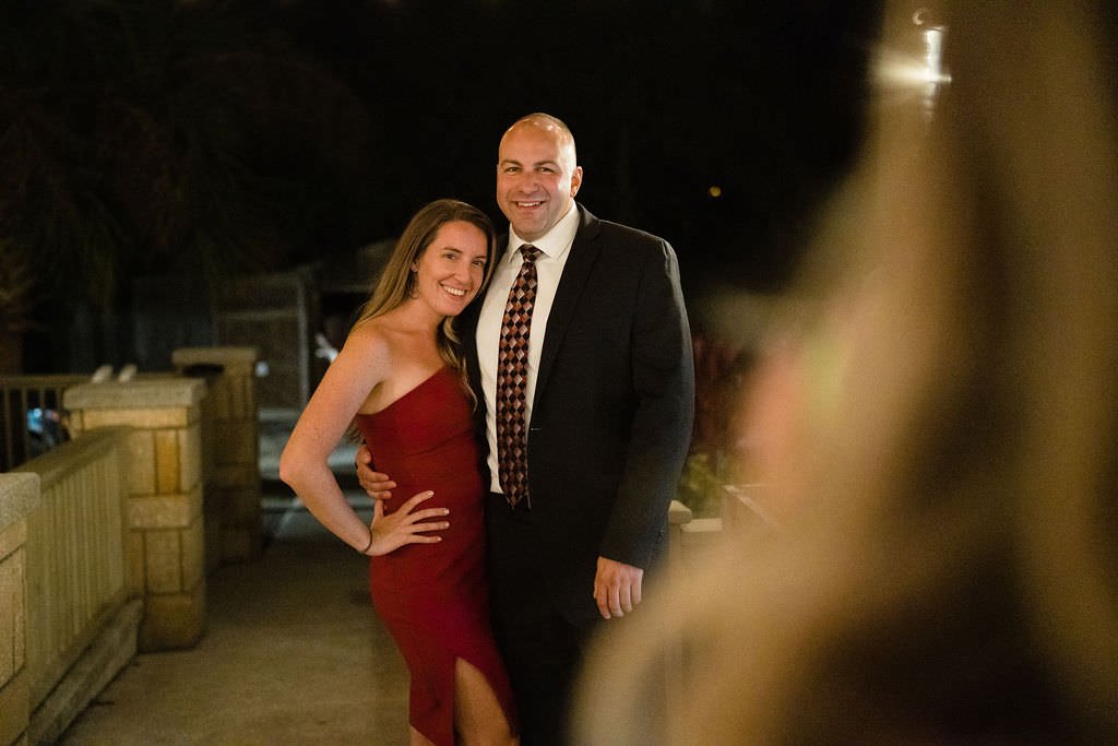 A happy couple poses for a photo at a wedding reception They are dressed up and smiling.jpg