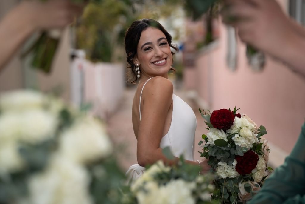 A joyful bride surrounded by flowers on her wedding day.jpg