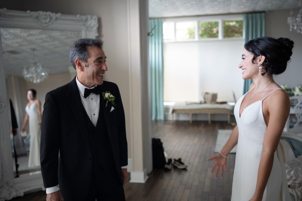 A joyful father sees his daughter in her wedding dress for the first time creating a heartwarming moment.jpg