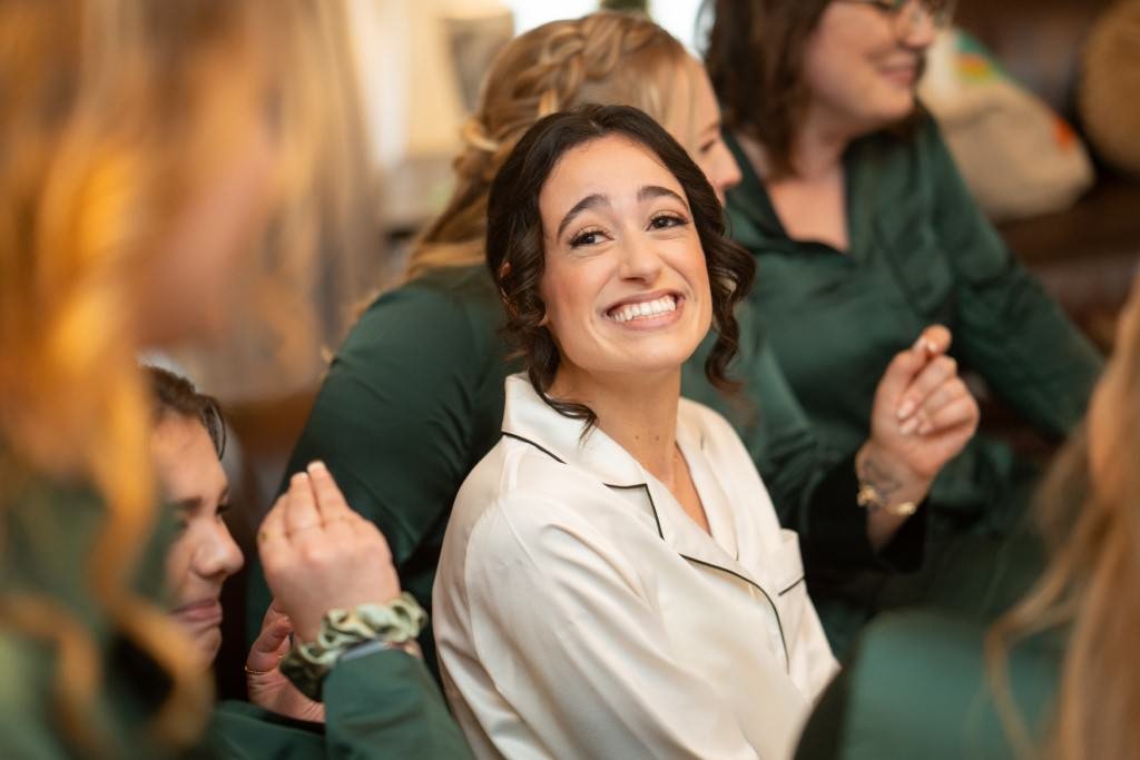 A joyful woman in white pajamas shares a happy moment with friends in green attire.jpg