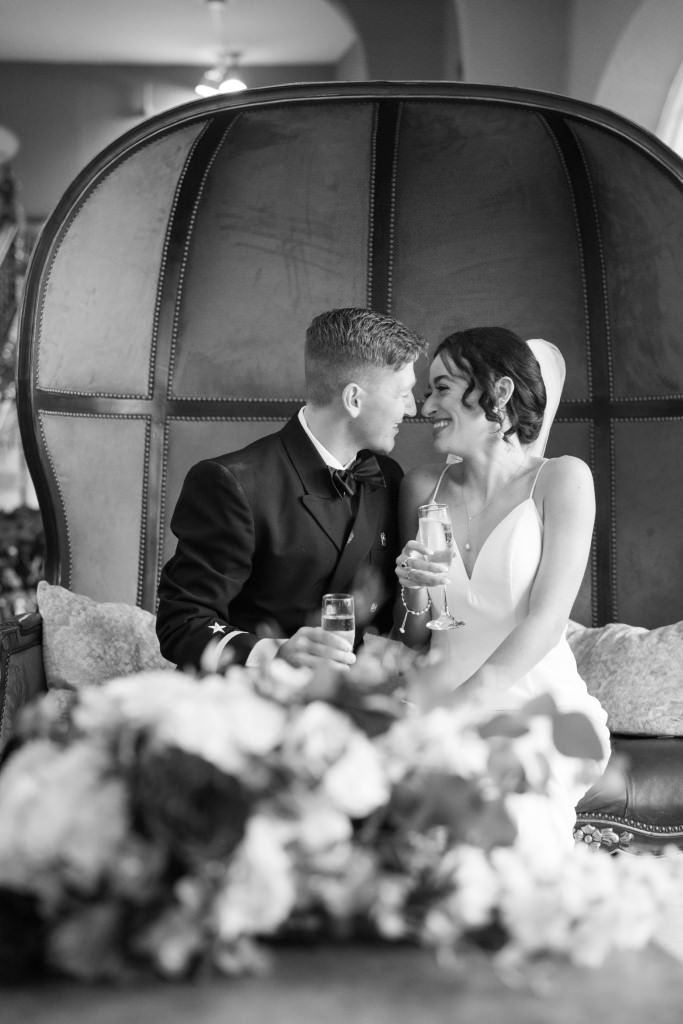 A newlywed couple shares an intimate moment on a cozy couch with glasses of champagne.jpg