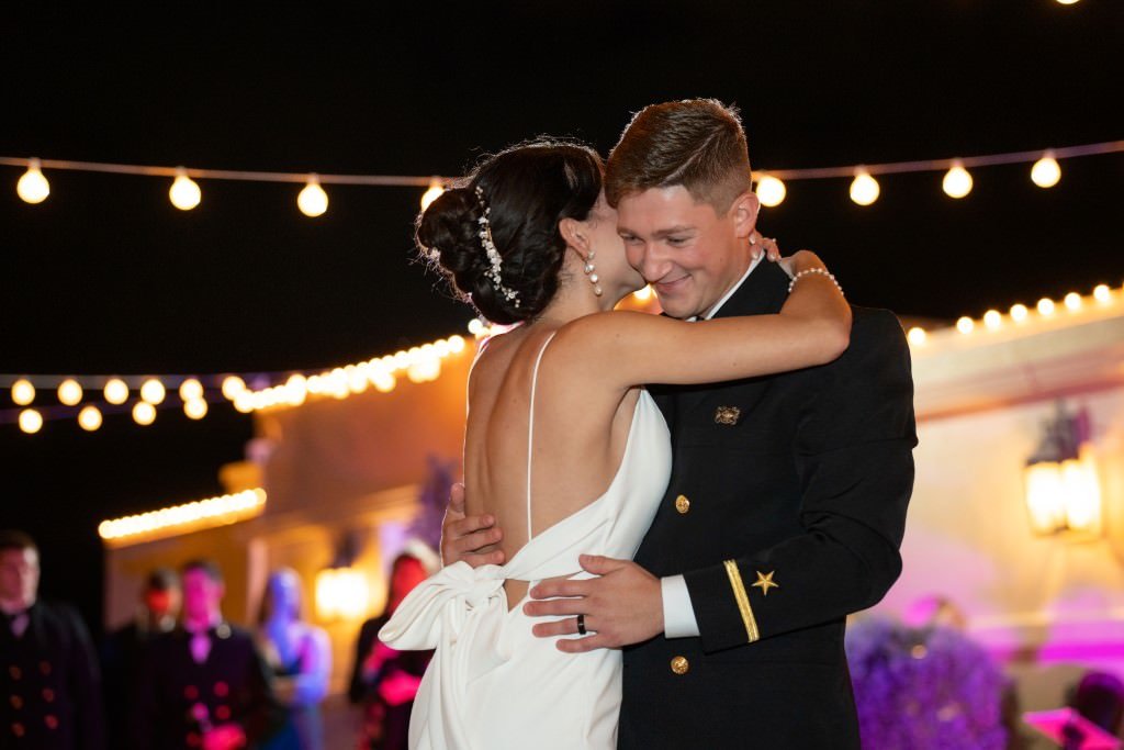 A newlywed couple sharing their first dance under romantic string lights.jpg