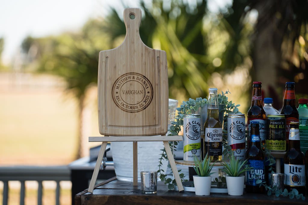 A personalized cutting board for the wedding of Matthew Deanna surrounded by drinks for the celebration.jpg