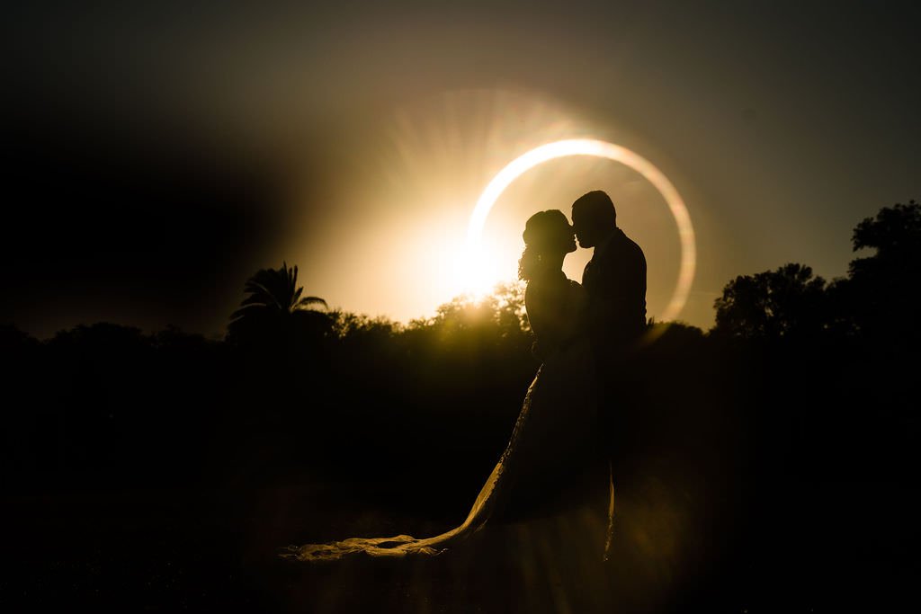 A silhouette of a couple embracing at sunset surrounded by a golden glow.jpg