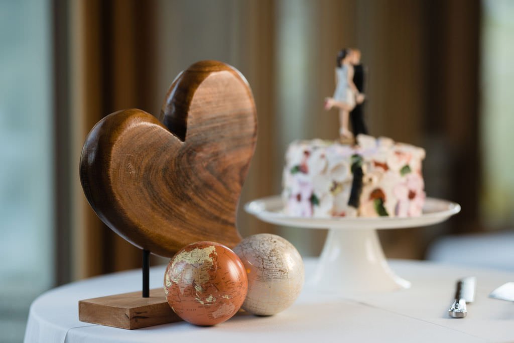 A wooden heart globes and a wedding cake symbolizing love the world and a new beginning.jpg