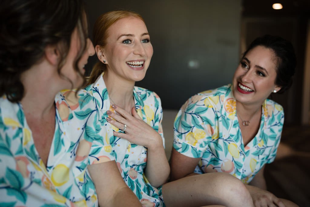 Bride and bridesmaids in matching lemon print pajamas laughing and getting ready for the big day bridesmaids gettingready weddingday lemonprint.jpg