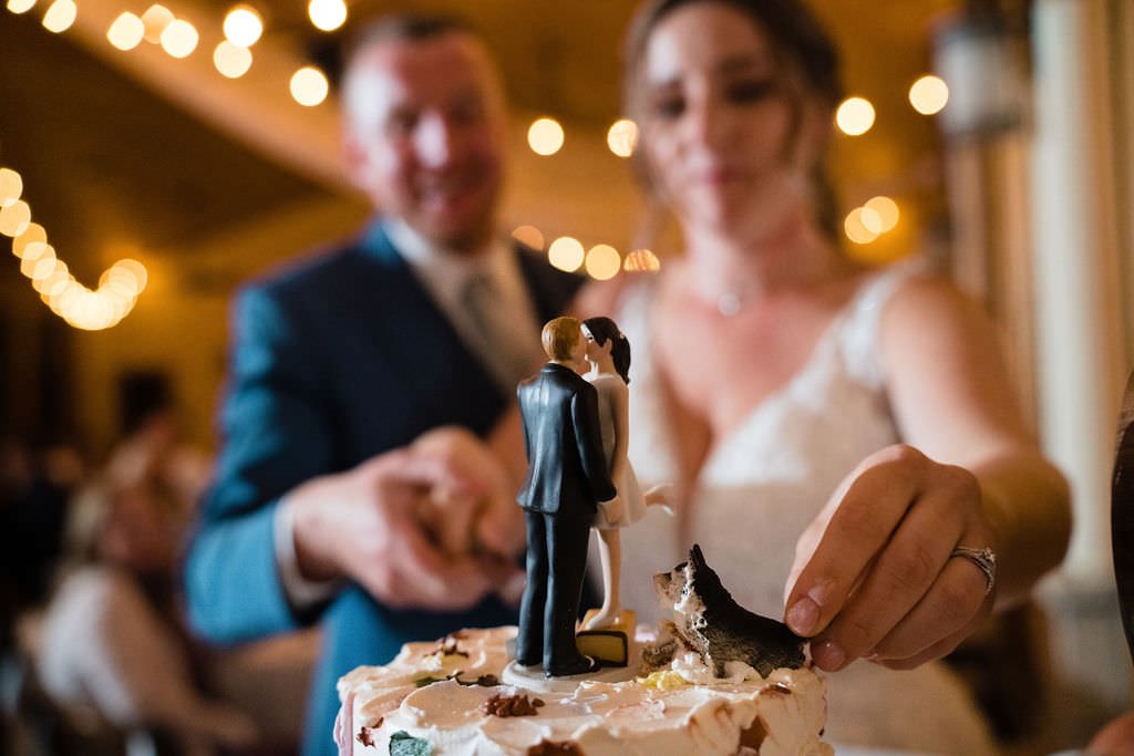 Bride and groom cutting their wedding cake with a cute little dog topper.jpg