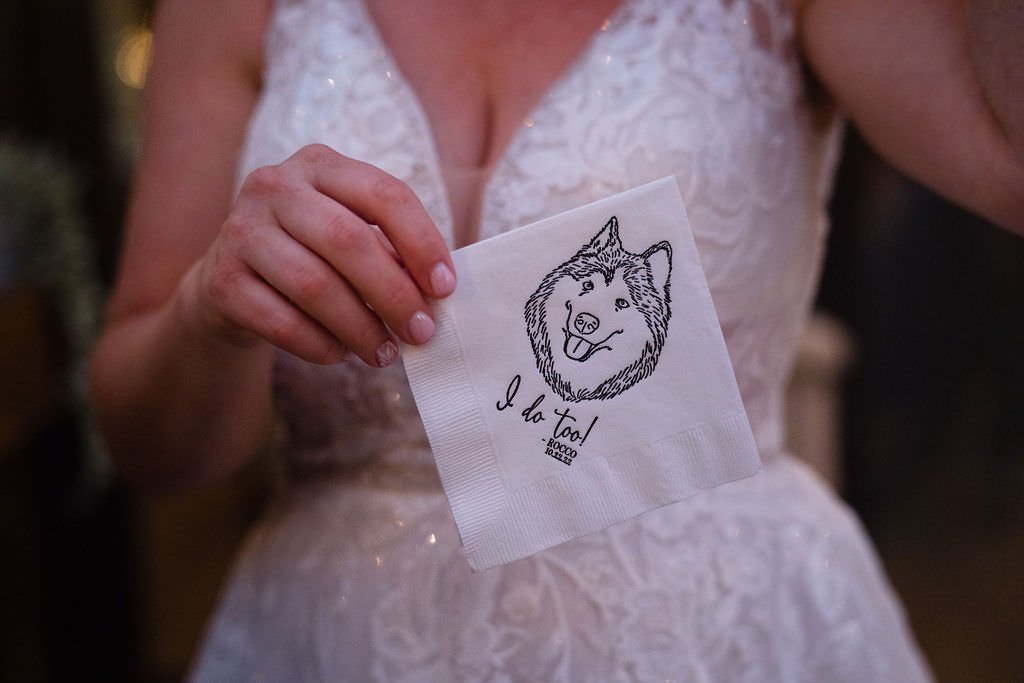 Bride holding a napkin with a dog on it that says I do too Cute and personal touch for a wedding.jpg
